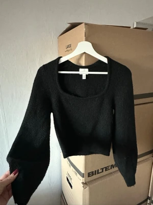H&M - Svart stickad topp från H&M med fyrkantig urringning och långa ärmar. Mjuk och skön, passar både till vardag och fest!