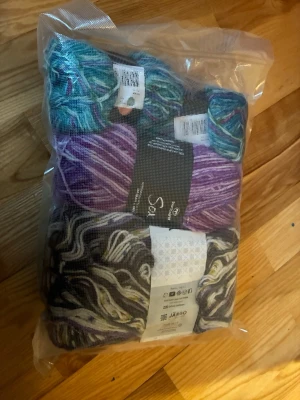 Stort paket blandade garnnystan - Säljer ett paket med flera garnnystan från Järbo i olika färger och mönster. Innehåller bland annat lila, grått, vitt och turkost garn. Perfekt för dig som gillar att sticka eller virka och vill ha många färger att välja på.