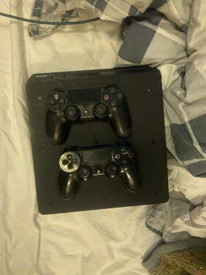 Sony PlayStation PS4 Slim + 2 kontroller – Spelklar direkt! - Säljer min PS4 Slim tillsammans med två vanliga kontroller. Perfekt paket för dig som vill komma igång direkt med gaming! • Konsolen är fullt fungerande och i gott skick • Två trådlösa kontroller medföljer • USB-kablar och strömadapter ingår • Idealisk för multiplayer och långa spelsessioner  Redo att spela – bara koppla in och starta!