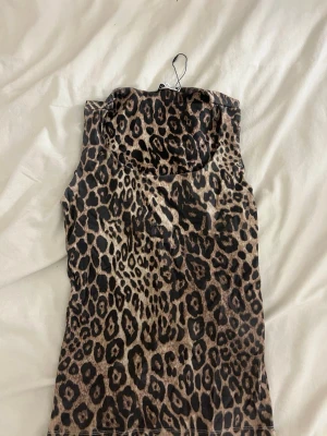 Leopardmönstrad ärmlös topp från Zara - Säljer en snygg ärmlös topp från Zara med leopardmönster i bruna och svarta toner. Toppen har rund halsringning och är i ett mjukt, stretchigt material som sitter tajt om kroppen. Är omsydd i banden då den var för lång/stor för mig men går enkelt att sprätta upp ifall det önskas🤗 !!Om du köper välj gärna att hämta vid upphämtningsställe då det blir enklare för mig att posta på det viset!!