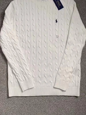 Vit kabelstickad tröja Polo Ralph Lauren - Kabelstickad vit tröja från Polo Ralph Lauren med rund halsringning och klassisk marinblå logga broderad på bröstet. Tröjan har ribbade muddar vid ärmslut och nederkant, vilket ger en snygg och tidlös look. Perfekt för dig som gillar stilrena plagg.