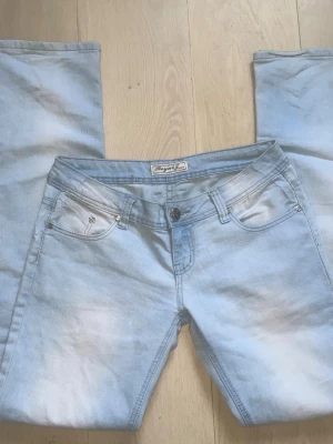 Ursnygga ljusblå bootcut jeans från Royal - Säljer ett par ljusblå bootcut jeans från Royal Jeans med klassisk femficksdesign. Jeansen har låg midja,  och silverfärgade detaljer. Modellen är straight legged och jättefina att ha som de är eller sy om till bootcut. Storlek S/M ungefär och midjemått 40cm. Köpta på vinter men aldrig använda💕(kan inte posta på en lite mindre än en vecka) Pris kan diskuteras