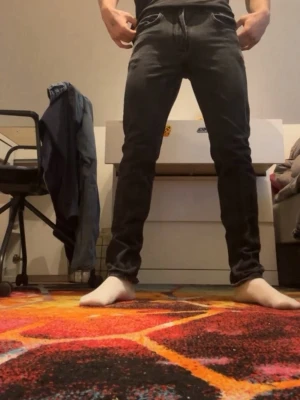 Svarta slim fit jeans - Säljer ett par svarta slim fit jeans med klassisk femficksdesign och normal midja. Jeansen har en stilren look och sitter tajt längs benen. Perfekta för dig som gillar en enkel och modern stil.