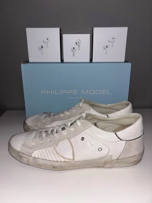 Philippe Model prsx + hörlurar - Ett par Philippe Model prsx, vita. Nypris: 3500kr+, mitt pris: 2399kr. Storlek 45. Skick 9/10, ser helt nya ut! Öppen för bud vid snabb affär! Du får även med dig ett valfritt par av de tre hörlurarna på bilden 🔥Hör av er vid frågor! Skickar snabbt ✅