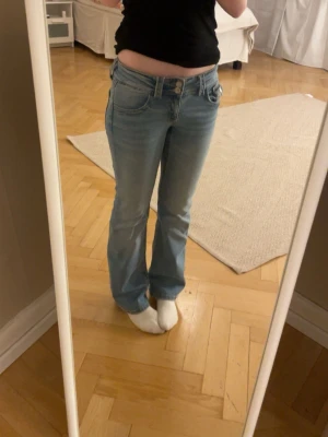 Ljusblå bootcut jeans med dubbla knappar - Säljer ett par ljusblå bootcut jeans med dubbla knappar i midjan. Då dem inye kommer till användning längre🥰