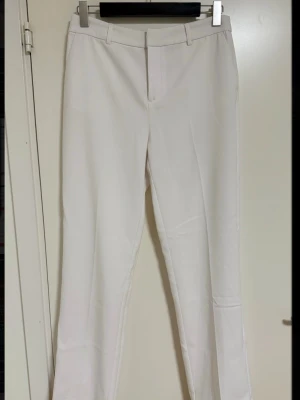 Vita kostymbyxor från Gina Tricot - Vita kostymbyxor från Gina tricot. Byxorna är helt oanvända, nyskick. Materialet känns slätt och har lätt stretch. Säljer då de inte kommer till användning💕