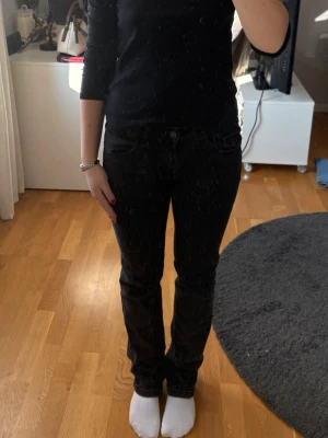 Svarta raka jeans - Säljer ett par svarta jeans med rak passform. Jeansen har låg midja och är tillverkade i ett mjukt denimtyg som. Väldigt sköna.