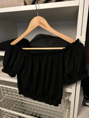 Svart offshoulder topp Gina Tricot - Säljer en svart offshoulder topp från Gina Tricot. Toppen har korta puffärmar och resår vid axlar, ärmslut och nederkant💞
