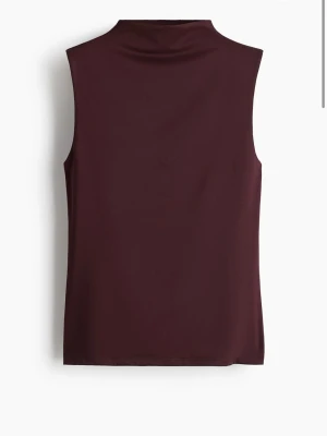 Mörkröd ärmlös polotopp - Säljer en vinröd polotopp från hm. Säljer pågrund av att den e för stor🥰