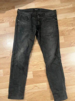Svarta Replay jeans med smal passform - Säljer ett par svarta jeans från Replay med smal passform och klassisk femficksdesign. En liten söm i skrevet men inget som syns på. Jeansen har en lätt tvättad look och dragkedja i myntfickan. Materialet är mjukt denim som sitter snyggt och bekvämt. Perfekta till en avslappnad streetstil. Dom har blivit för små för mig därför säljer jag för detta låga priset💸🔥