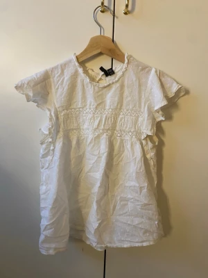 sommrig blus me detaljer - jätte söt blus me små detaljer och volanger vid armarna! bra skick men små täcken på användning men verkligen jätte små man märker lixom knappt det!