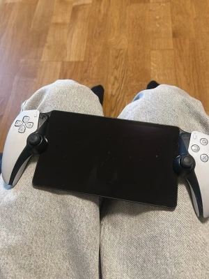 Playstation Portal fjärrkontroll PS5  - Säljer denna Playstation Portal fjärrkontroll, därför att jag inte använder den mycket och den vägrar funka till mitt nätverk. Den funkar endast för PS5 kopplas till samma WI-FI som din PS5 WI-FI. Sedan ganska enkel att använda precis som en PS5. Enkel att ta med utomlands eller om man är ute med vänner. Kan spelas vad som helst på den. Tex. GTA 5, RE spelen osv. Rekommenderar att ni har en PS5 för den funkar tyvärr inte utan och ni är nogranna med att den funkar bara med samma WI-FI som din PS5