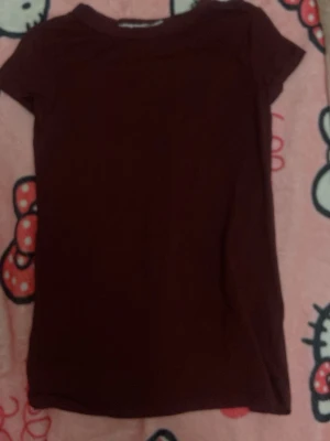 Mörkröd basic t-shirt - En enkel mörkröd t-shirt med korta ärmar och rund hals. Perfekt till jeans eller kjol för en clean och stilren look. Gjord i mjukt bomullstyg som känns skönt mot huden.