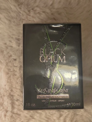 Yves Saint Laurent Black Opium Illicit Green - Yves Saint Laurent Black Opium Illicit Green är en parfym i en elegant svart och grön förpackning med glittrande detaljer. Flaskan rymmer 30 ml och har en modern, lyxig design med tydlig YSL-logga. Doften är en Eau de Parfum och levereras som spray.