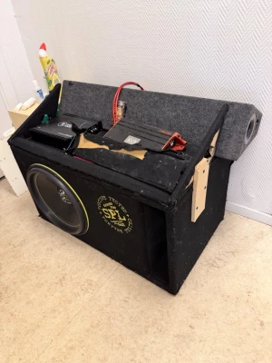 SPL bilstereo med högtalare och slutsteg - Säljer ett komplett bilstereopaket från SPL med stor baslåda, flera högtalare och två slutsteg. Lådan är svart och klädd i tyg, med SPL-logga i gult. Perfekt för dig som vill ha kraftigt ljud i bilen. Inkluderar kablar och monteringsdetaljer.