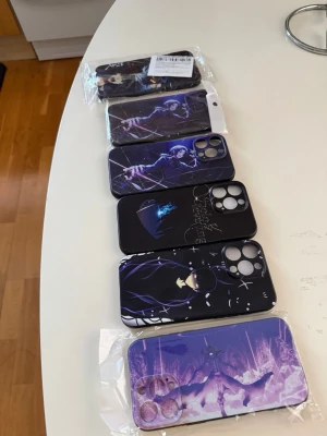 Iphone 16 pro max Anime-inspirerade mobilskal lila/svart - Säljer fem mobilskal med anime-motiv i lila och svart. Skalen har olika karaktärer och coola illustrationer, perfekta för dig som gillar anime och vill ha en unik look på mobilen. Materialet är hårdplast och skalen har öppningar för kamera och knappar.