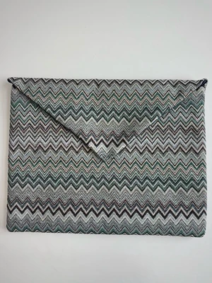 Zigzag-mönstrad datorväska i tyg - Snyggt datorfodral i tyg med blått zigzag-mönster. Väskan har en klassisk kuvertform med spetsigt lock som stängs med en dold knapp. Perfekt accessoar för att lyfta din outfit. De är handgjorda och inuti finns det en ficka samt resorband för att organisera pennor. (Kika in vår TikTok för fler bilder @shelly.uf)