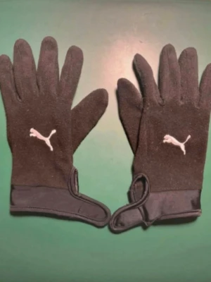 Puma Spelarhandskar Teamliga 21 - Svart/Vit - I mycket bra skick och knappt använda. Passar till alla typer av händer. Storlek M (långfingret till handled 22 cm). Nypris 299kr.  Mjuka handskar för kalla vinterlekar och träningar. Lätt akrylmaterial håller händerna varma och säkerställer en snäv passform. Silikon i fingrarna.
