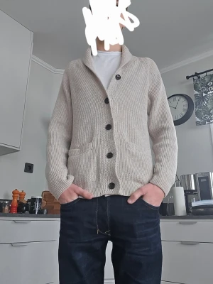 Beige ribbad kofta med stora knappar - Riktigt snygg beige kofta med ribbad struktur och svarta knappar💪. Koftan har två fickor och en bred krage. Nyskick 🙌 passar S/M.