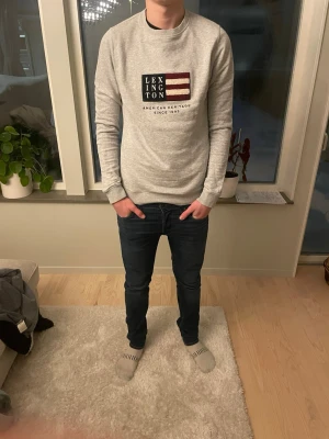 Lexington tröja grå - Tja säljer en Snygg grå sweatshirt från Lexington med amerikanskt flaggtryck och text på bröstet. Tröjan har rund halsringning, långa ärmar och ribbade muddar. Perfekt för en avslappnad och stilren look. Storlek S och jag på bilden är 180 ish😁skick 10/10🤩har du några mer frågor eller funderingar är de bara att höra av sig🙌🏼mvh premium fashion 