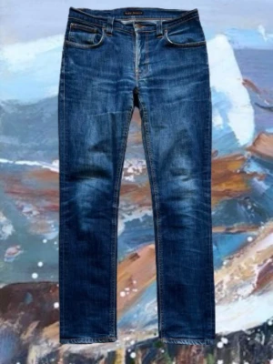 Blåa Nudie jeans - Säljer dessa blåa nudie jeans som är storlek W33 L32. De är extremt mjuka och sköna, de har blivit lagade några gånger av föra ägaren men det syns inte. Vid frågor och funderingar hör järna av dig!