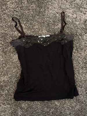 Vintage brun topp med spets och paljetter - Köpt secondhand för ett tag sedan. Lappen med storleken på är bortklippt men skulle gissa på att det är M/L i storlek. Den är dock ganska kort så man kan lätt sy in den lite på sidorna om man är mindre