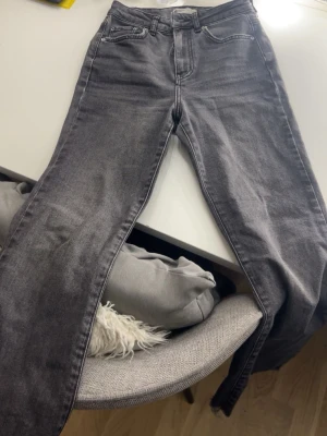 Grå raka jeans med hög midja - Säljer ett par grå jeans med hög midja och raka ben. Är 163 då de är korta då modellen är så säljer för de börjar bli för små skitsnygga speciellt till sommaren nu passar även storlek xxs! Inga defekter!