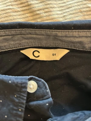 Mörkblå prickig skjorta - Snygg mörkblå skjorta med vita prickar och klassisk krage. Skjortan har långa ärmar och vita knappar framtill samt vid ärmsluten. Perfekt för dig som gillar stilrena detaljer och ett modernt uttryck. OBS! Kommer strykas innan jag skickar den!