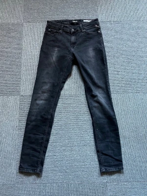 Svarta skinny jeans från Replay - Snygga svarta skinny jeans från Replay med klassisk femficksdesign och diskreta slitningar. Jeansen har en smal passform och är tillverkade i stretchigt denimtyg för extra komfort. Perfekta för dig som gillar en stilren och modern look.