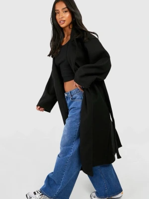 Svart lång kappa med lite oversized passform - Stilren svart kappa med rak och oversized siluett. Kappan har breda ärmar, enkel knäppning och är gjord i ett mjukt material som ger en cool look. Perfekt för lager-på-lager och att matcha med jeans eller sneakers. Prislapp kvar