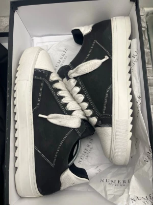  Numeris sneakers - Snygga sneakers från Numeris i svart och vitt med breda snören. Använda under en månads tid och är knappt slitna under (kolla bild) säljs då jag börjat använda något annat. Snören är lite smutsiga därav priset men går att rengöras ifall dom tas av men har ej orkat att göra det själv.