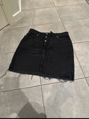 Kort jeanskjol  - Svart kort jeanskjol i gott skick. Sparsamt använd. 