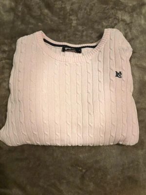 Ljusrosa kabelstickad tröja Gina Tricot - Supersöt ljusrosa kabelstickad tröja från Gina Tricot med rund halsringning och diskret broderad logga på bröstet. Tröjan har långa ärmar och ribbade muddar vid ärmslut och nederkant. Perfekt för lager-på-lager och chill dagar. Använd några få gånger då tröjan är för liten för mig och är i väldigt bra skick!!