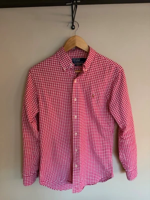 Polo Ralph Lauren skjorta - Säljer min rosa/röd rutiga skjorta pga att den är för liten. Skjortan är i ny skick och endast använd fåtal gånger.