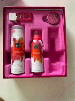 Rituals The Ritual of Holi presentbox - Presentbox från Rituals med serien The Ritual of Holi. Innehåller duschskum, kroppsmousse, parfym och en liten burk body cream. Färgerna går i vitt, rosa och orange med färgstänk. Parfymflaskan har en rosa glasdesign och vitt trälock. OBS! ENDAST upphämtning i Malmö!