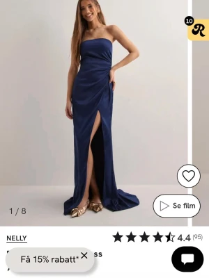 Marinblå axelbandslös långklänning - Elegant marinblå axelbandslös långklänning med slits framtill. Klänningen har en figurnära passform och är tillverkad i ett glansigt, mjukt material som ger en lyxig känsla. Perfekt för speciella tillfällen till exempel bal, pris kan diskuteras 🩷