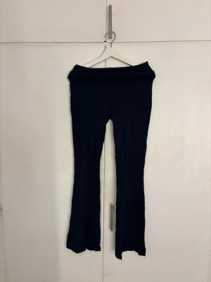 Mörkblå utsvängda leggings - Säljer ett par mörkblå leggings med utsvängda ben och hög midja. De är stretchiga och mjuka, perfekta för en avslappnad och trendig look. Inga synliga fickor eller detaljer, enkel och stilren design.