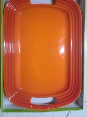 Orange ugnsform från Le Creuset - Säljer en rektangulär ugnsform i keramik från Le Creuset i en snygg orange färg. Formen har praktiska handtag på sidorna och är perfekt för gratänger, lasagne eller bakning. Klassisk design med Le Creuset-logga på undersidan.