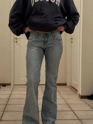 Ljusblå bootcut jeans - Säljer ett par ljusblå bootcut jeans med klassisk femficksdesign och normal midja. Jeansen har en avslappnad passform över låren och lätt utsvängda ben. Perfekta för en casual och trendig look.