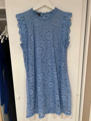 Blå spetsklänning med volangärm - Supersöt blå kortklänning i spets med volangdetaljer vid ärmarna. 