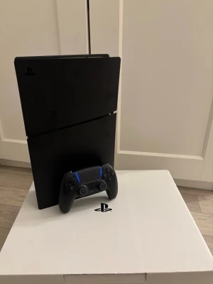 PlayStation 5 Slim med handkontroll - Säljer en svart PlayStation 4 Slim från Sony tillsammans med en matchande svart DualShock 4-handkontroll. 