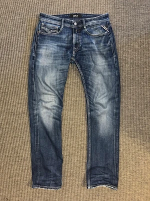 Replay blå jeans straight fit - Säljer ett par Replay jeans i blå tvätt med snygga slitningar och raka ben. Passformen är straight och materialet är robust denim som sitter skönt hela dagen. Lite slitet i skrevet annars perfekta. Priset kan diskuteras vid snabb affär och vid minsta fundering tveka inte på att höra av dig.