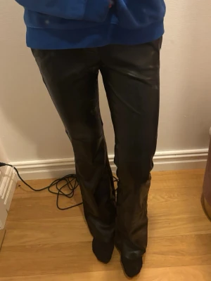 Svarta low waist skinnbyxor från Bershka - Säljer ett par svarta byxor i fuskskinn från Bershka. Byxorna har en flared passform och låg midja, vilket ger en snygg och trendig look. Använda fåtal gånger💕
