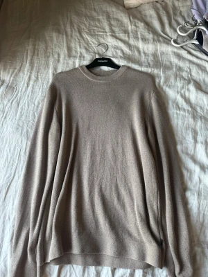 Beige stickad tröja Jack & Jones - OBS använd 1 gång! Snygg beige stickad tröja från Jack & Jones i storlek M. Tröjan har rund halsringning, långa ärmar och ribbade muddar vid hals, ärmslut och nederkant. Perfekt för lager på lager och enkel att matcha med olika outfits.