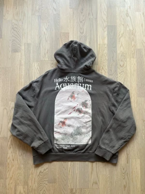 ASOS Design hoodie med tryck - grå, XL - Mycket bra skick. Inga tecken på användning Hoodie från ASOS Design, storlek XL, grå Huva utan snörning, stort tryck med text på ryggen, stor framficka. Bröstvidd: 64 cm Längd: 62 cm Bomull, 4% elastan Inga defekter