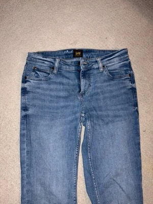 Blå Lee jeans med raka ben - Snygga blå jeans från Lee med klassisk femficksdesign och raka ben. Jeansen har normal midja, bälteshällor och Lee-logga på bakfickan. Tillverkade i mjukt denimtyg som ger en avslappnad look. NYA KOSTAR 1000kr