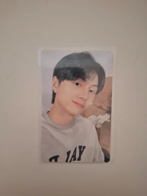 Enhypen Jay photocard CCUCCU - Säljer en photocard med Jay från Enhypen, CCUCCU PACKAGE. Kortet har en bild på Jay på framsidan och rosa design med text och kattmotiv på baksidan. Perfekt för samlare av K-pop merch.