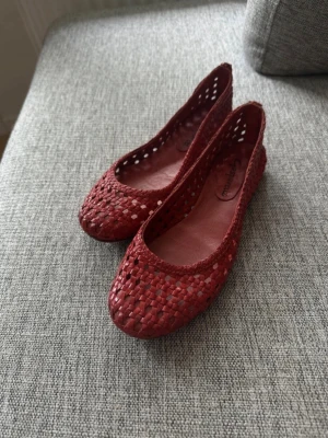 Vinröda flätade ballerinaskor - Säljer ett par vinröda ballerinaskor med flätad design. 