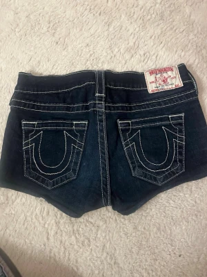 Mörkblå jeansshorts från True Religion - Lågmidjade jeansshorts från true religon! Midjemått- 33 cm