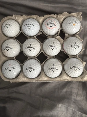 Callaway golfbollar  - Säljer ett set med 12 vita golfbollar från Callaway, med olika nummer och färgmarkeringar. Bollarna har klassisk dimple-design och logotyp. Perfekt för golfentusiasten som vill ha variation på banan.